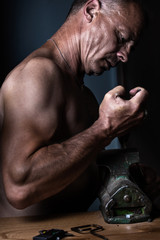 Muscular Middle Aged Artisan working with Metal Vise at his Workshop