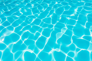 Fototapeta na wymiar Ripple blue water in swimming pool witn sun reflection