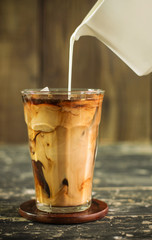 Pouring the milk in iced coffee
