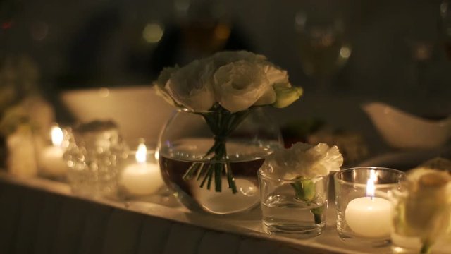 Beautiful wedding decoration on ceremony table, made of white flowers and candles.