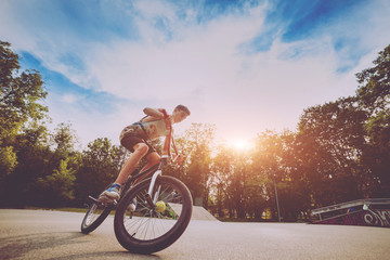 Boy riding a bmx in a park.