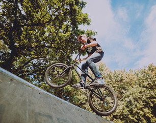 Boy jumping with his bmx in the park.
