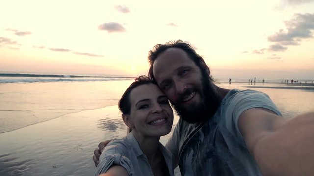 Young, happy couple taking selfie on beach during sunset, super slow motion 240fps
