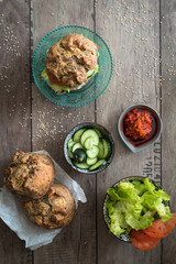 pane fatto in casa, lattuga, pomodori, cetrioli e salse per condire hamburger vegetariano. Vista dall'alto 