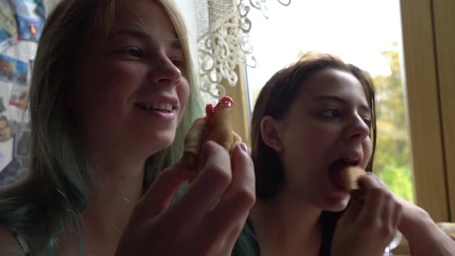 Two beautiful caucasian woman having eating pancakes together. Morning breakfast