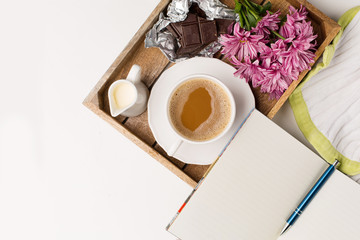 Cup of coffee, Bouquet of pink flowers, Chocolate and Empty paper notebook, top view