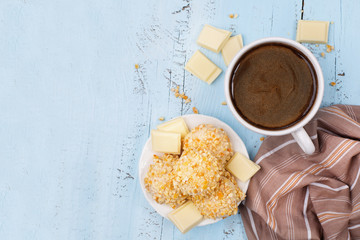 Cup coffee and homemade white chocolate cookies, blue table, top view