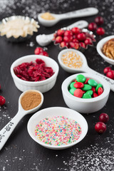 Christmas baking cupcake decorations and sprinkles, black background, selective focus. Holiday concept
