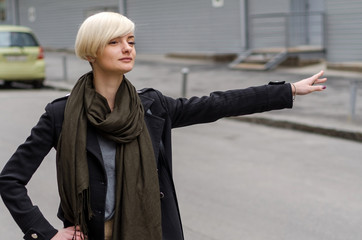 Young blonde woman catching the taxi 