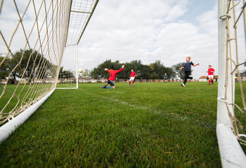 boy kicking a ball at goal