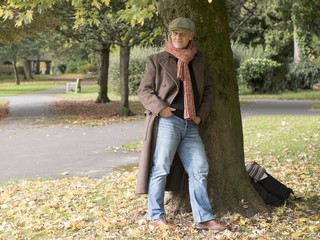 Fototapeta premium Portrait of a mature man standing under a tree outdoors. 