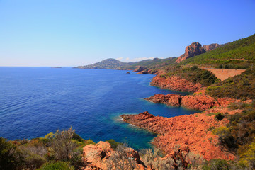 Fototapeta na wymiar Esterel mediterranean red rocks coast, beach and sea. French Riviera in Cote d Azur near Cannes Saint Raphael, Provence, France, Europe