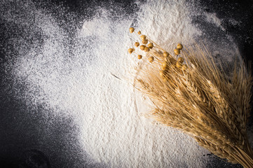 Scattered flour and wheat ears. On a black background.Top view. Flat lay.