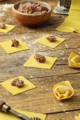 pasta fresca fatta a mano tortellini ripieni su tavolo di cucina rustico