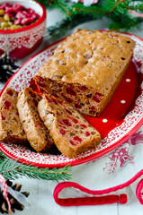 Traditional Christmas cake with dried fruits on a red plate