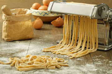 tagliatelle all'uovo pasta fatta a mano su tavolo rustico di legno