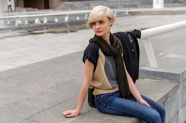 Young blonde girl walking on the city