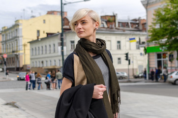 Young blonde girl walking on the city