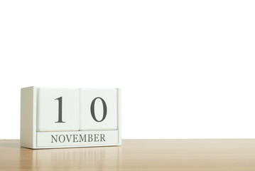 Closeup surface white wooden calendar with black 10 november word on blurred brown wood desk isolated on white background with copy space , selective focus at the calendar