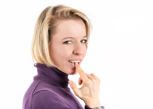 Shot of a blonde woman putting her finger in her mouth in front of a white background