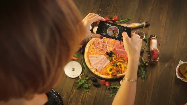 Woman taking a photo of pizza