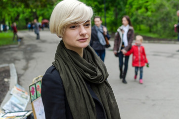 Young blonde girl walking on the city