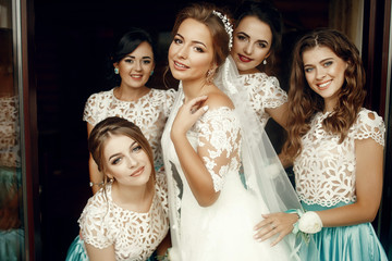 Bride holds her hand on the shoulder while bridesmaids hug her