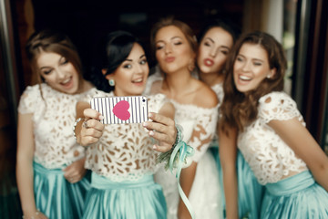 Fototapeta premium Pretty bridesmaid takes picture with bride