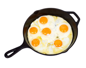 Fried eggs on cast iron skillet with salt isolated on white background