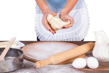 The woman kneads dough. In the apron. On white, isolated background.