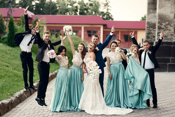 Groomsmen jump around beautiful wedding couple