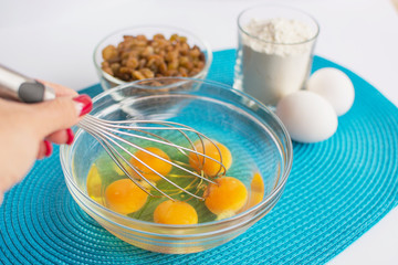 glass bowl with chicken eggs and female hand with whisk, set of