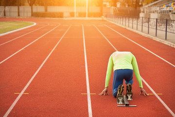 Young sporty man are ready to run on racetrack. Fit well formed people at large nice modern stadium