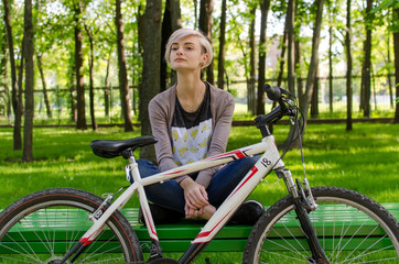 Obraz na płótnie Canvas Young girl with bicycle in the park