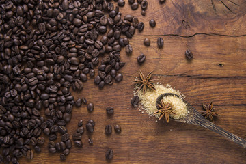 Coffee with brown sugar and anise on old wooden background.