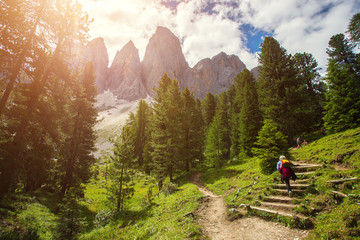 Group of Hikers walking on a mountain trail in vall di Funes, Dolomite Alps, Northern Italy