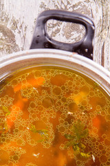 Chicken soup with carrots and parsley in a pot