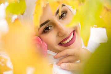 Beutiful Girl With Hijab among the leaves with a beautiful smile