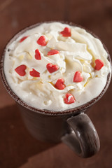 cup of coffee with whipped cream and red hearts