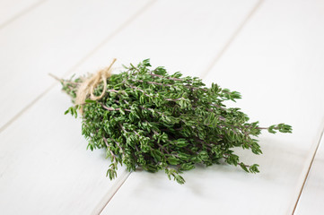 Bunch of fresh thyme on wooden white table.