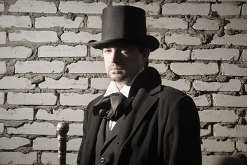 Victorian man in the black coat, top hat and in a tie