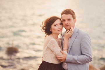 Romantic and stylish caucasian couple hugging at sunrise. Love, relationships, romance, happiness concept.