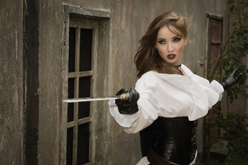 Sexy woman in pirate style holding sword