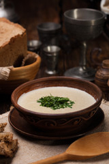 Creamy mushroom soup with herbs on  background of authentic dish