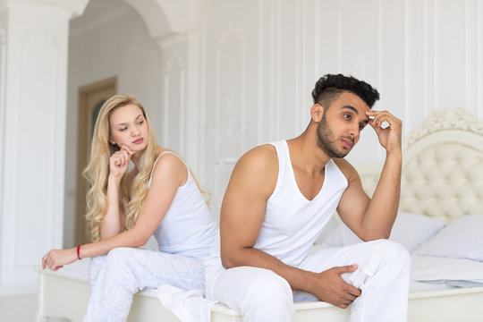 Young Couple Sitting Separate On Bed, Having Conflict Relationships Problem, Sad Negative Emotions Hispanic Man And Woman Lovers Argue In Bedroom