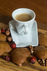 Cup of coffee with Lined gingerbread and nuts walnut and hazelnut on the wooden background