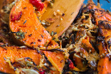Vegetarian baked dish close-up with pumkin, vegetables, herbs, c