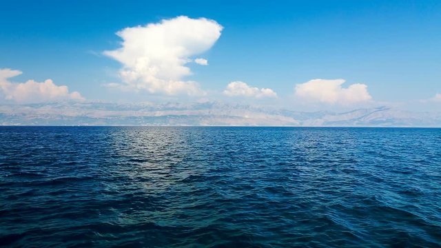 Beautiful Blue Sea and White Clouds. Adriatic Sea, Dalmatia, Croatia, Europe. Mountains in Haze on the Horizon. Summer Mediterranean Seascape.