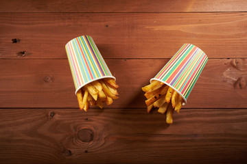 Naklejka premium fried French fries close up in paper cup