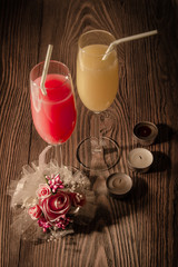 glasses of juice on a wooden background with candles